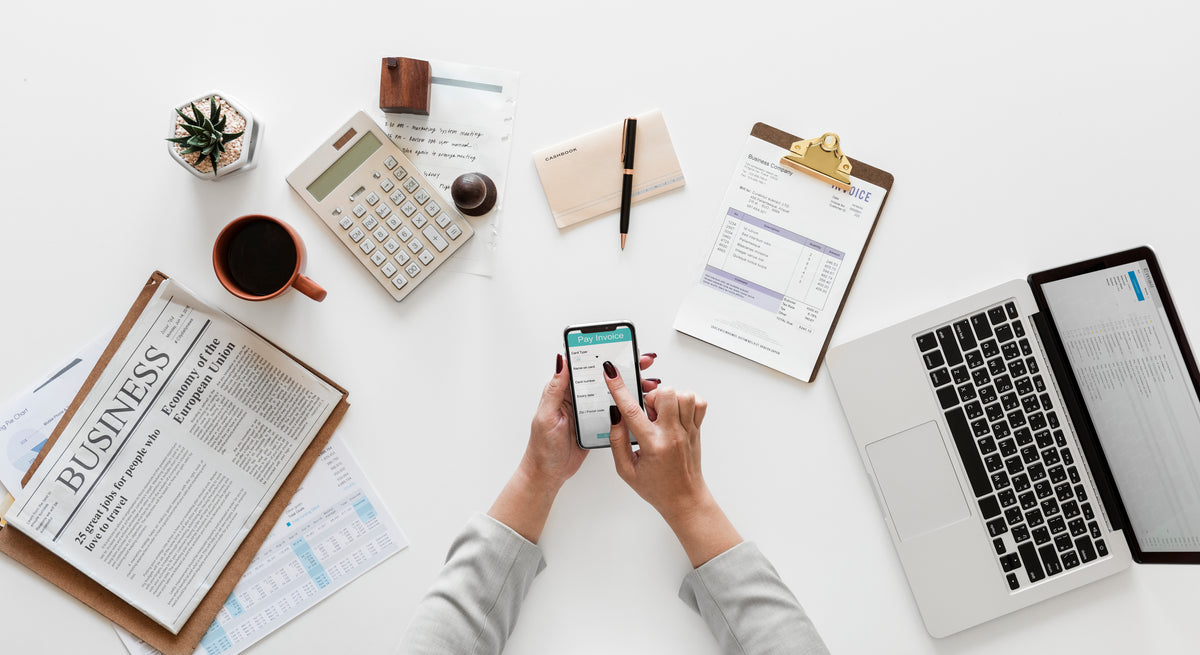 Invoices, reporting and a laptop on a desk — the operational side of running paid media